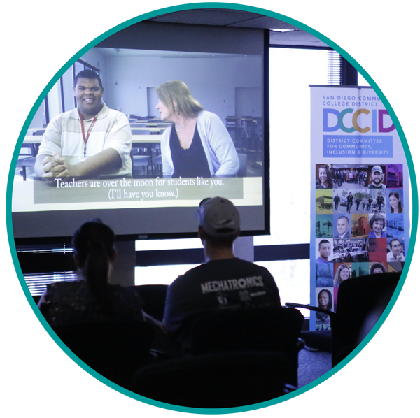 Two students watching a DCCID presentation on a screen