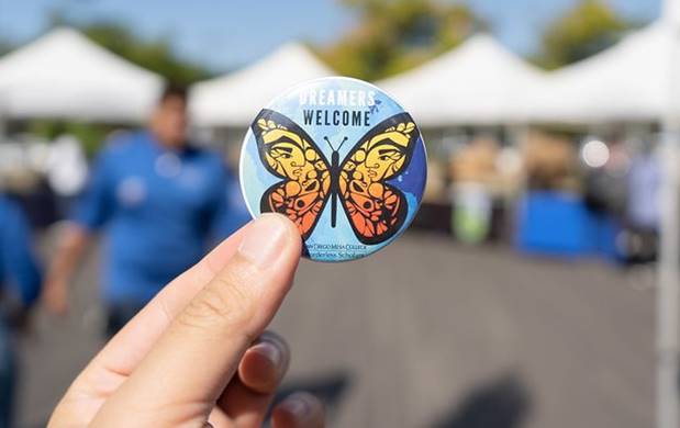 A Dreamer pin with a butterfly on it